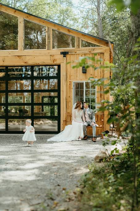 The timber cottage with a glass garage door, a couple resting on the step
