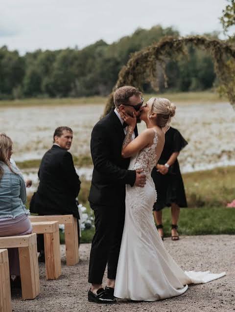 A couple sharing their first kiss at the lakeside ceremony
